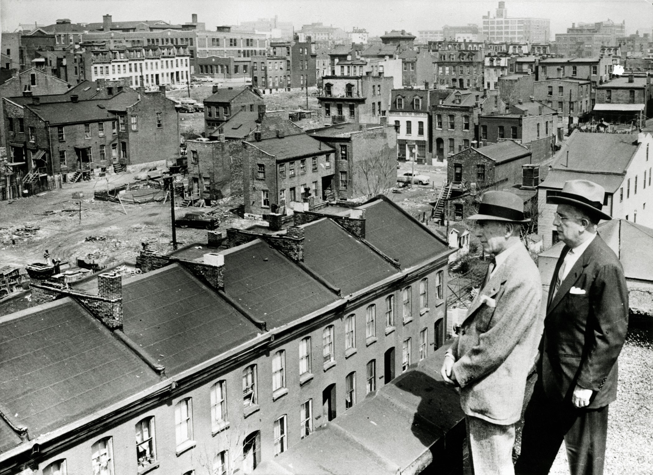 Sidney Maestre and Mayor Raymond Tucker on rooftop overlooking area of  Mill Creek Valley slated for clearance. Photograph, 1956. Missouri History Museum Photographs and Prints collections. St. Louis Redevelopment Projects Collection. n20908.